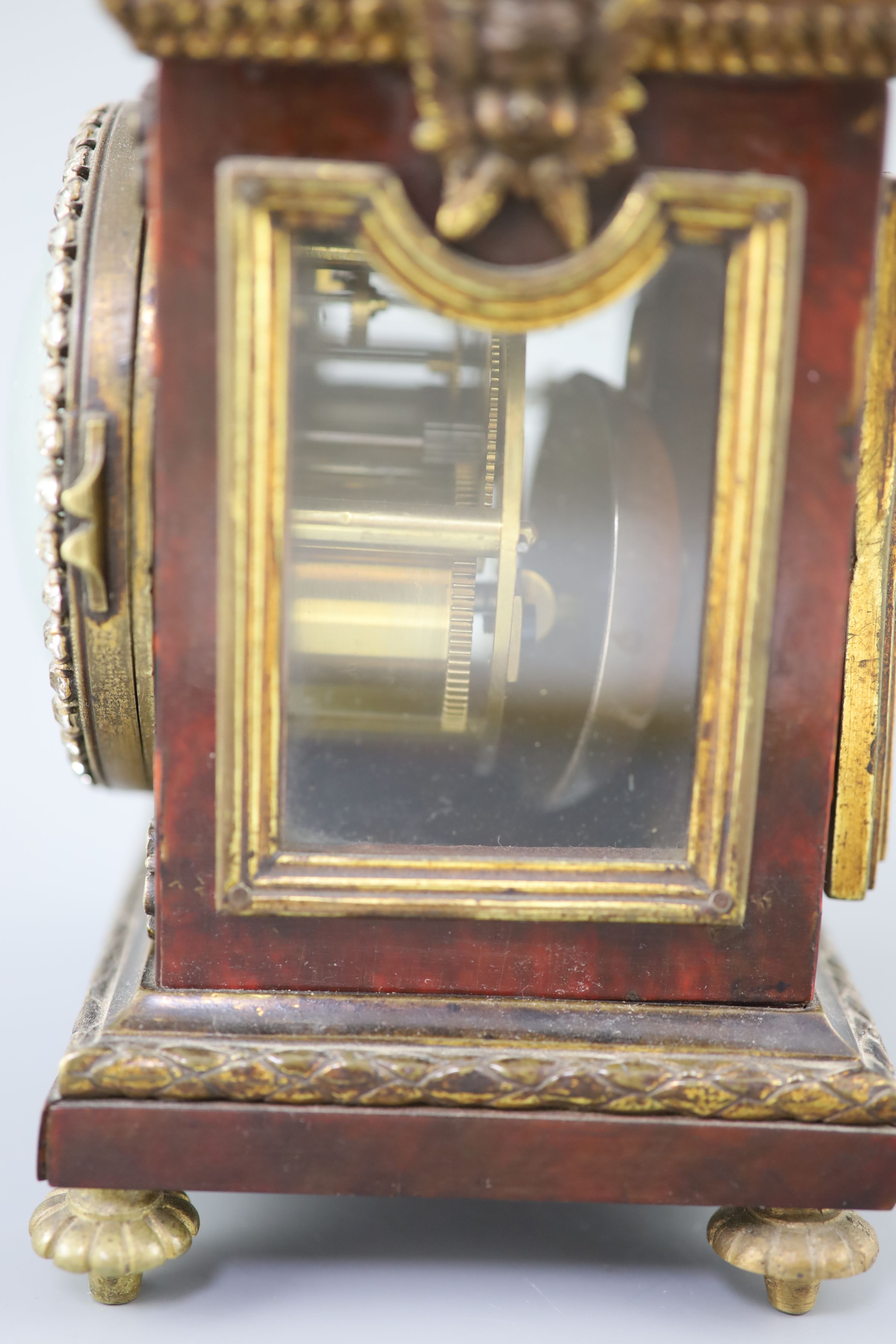 An early 20th century red tortoiseshell veneered mantel timepiece, height 8in.